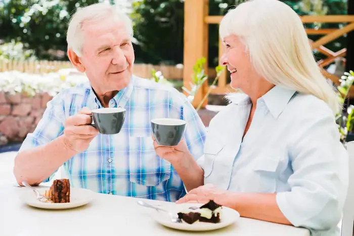 An older couple enjoying coffee and conversation outdoors